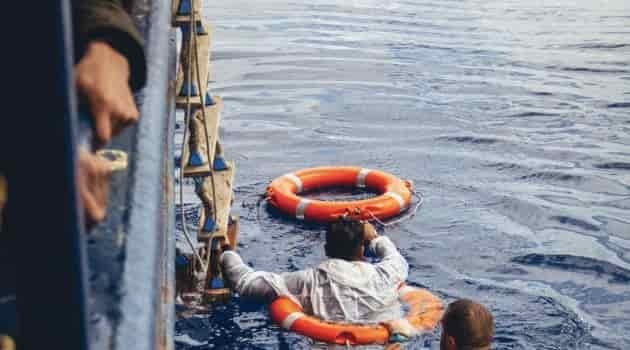 man saving an overboard passenger with a throne reach device