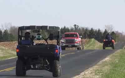utv and atv traveling down asphalt road with pickup truck on coming no license plate on utv ot atv