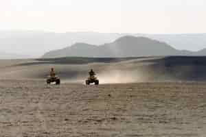 two-people-riding-atv-on-desert