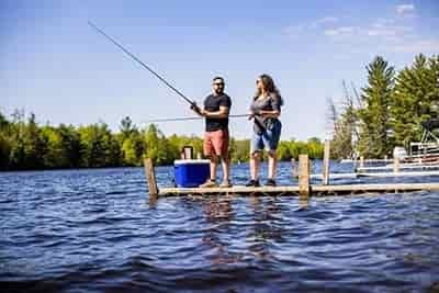 talking man and woman lake fishing together on pier