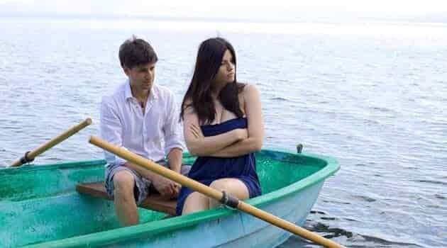 couple in row boat with no life vests arguing