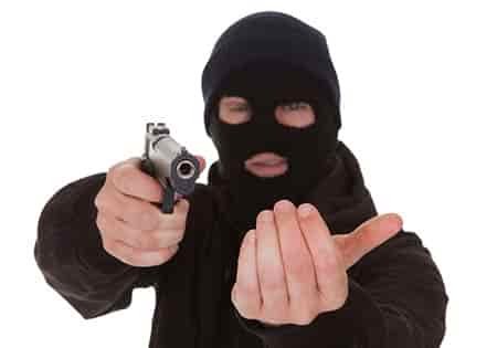 man robbing at gun point with mask on