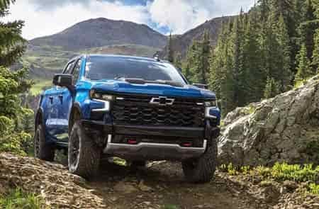 off roading on trilas in wooded area in chevrolet pick up truck