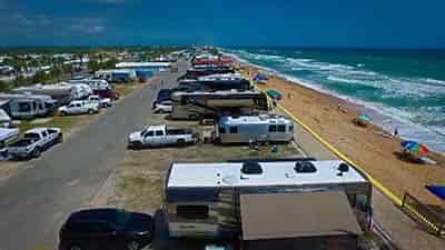 ocean side rv campground filled with travel trailers and motorcoaches on a beautiful day near pensacola florida