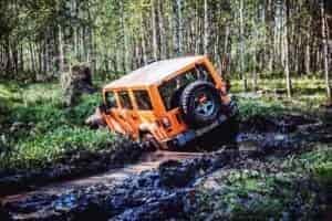 off roading in jeep in mud and water hole in off road park