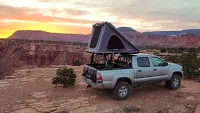 popup rooftop tent overlooking grand canyon mounted on a mid size pickup truck