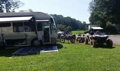 mines and meadows atv resort with motocoach, motorcross bike, ATV and side by side parked in camping area