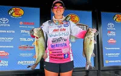 fishing tournament winner holding two large bass with polarized sunglsses on 