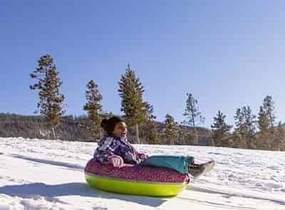 girl riding tube down snow slope