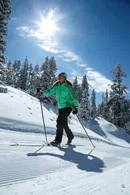 man cross country skiing up hill