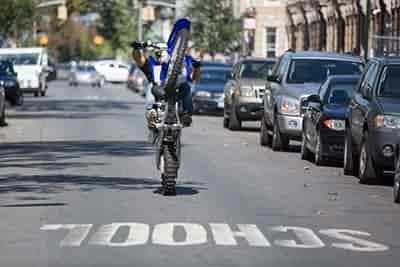 man on street with dirt bike school zone