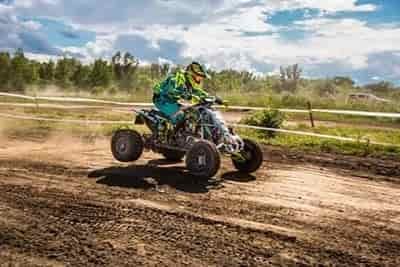 person-riding-atv-on a dirt track under-sunny