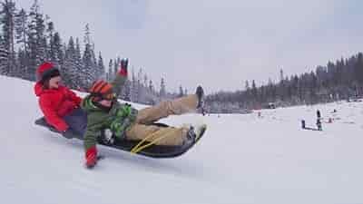 two boys coming out of sled
