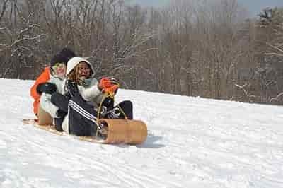 two women sledding down slope