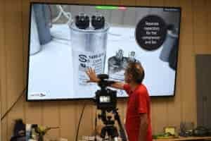 teacher working from overhead projection screen for large class