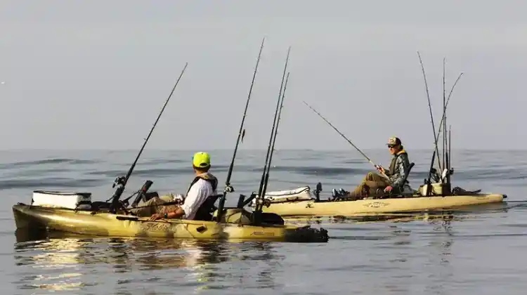 2 men in different kayaks in open water fishing vs bass boat fishing
