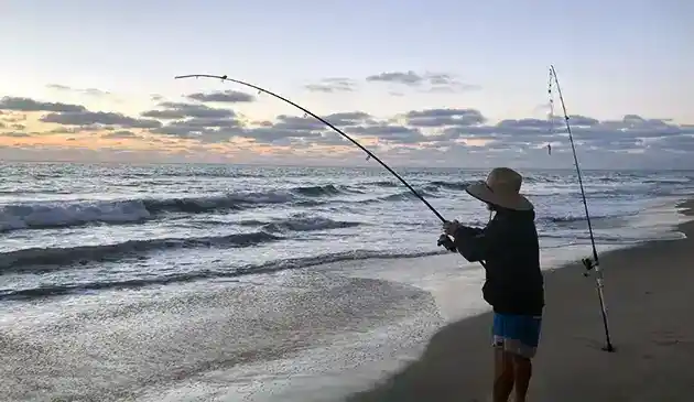 surf fishing at sunset with correct rod and reel