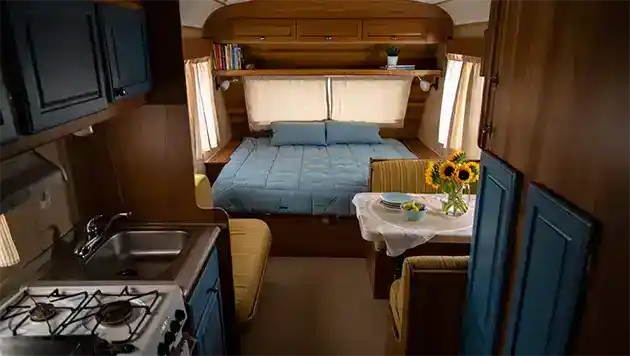 Small travel trailer bedroom, dining and kitchen
